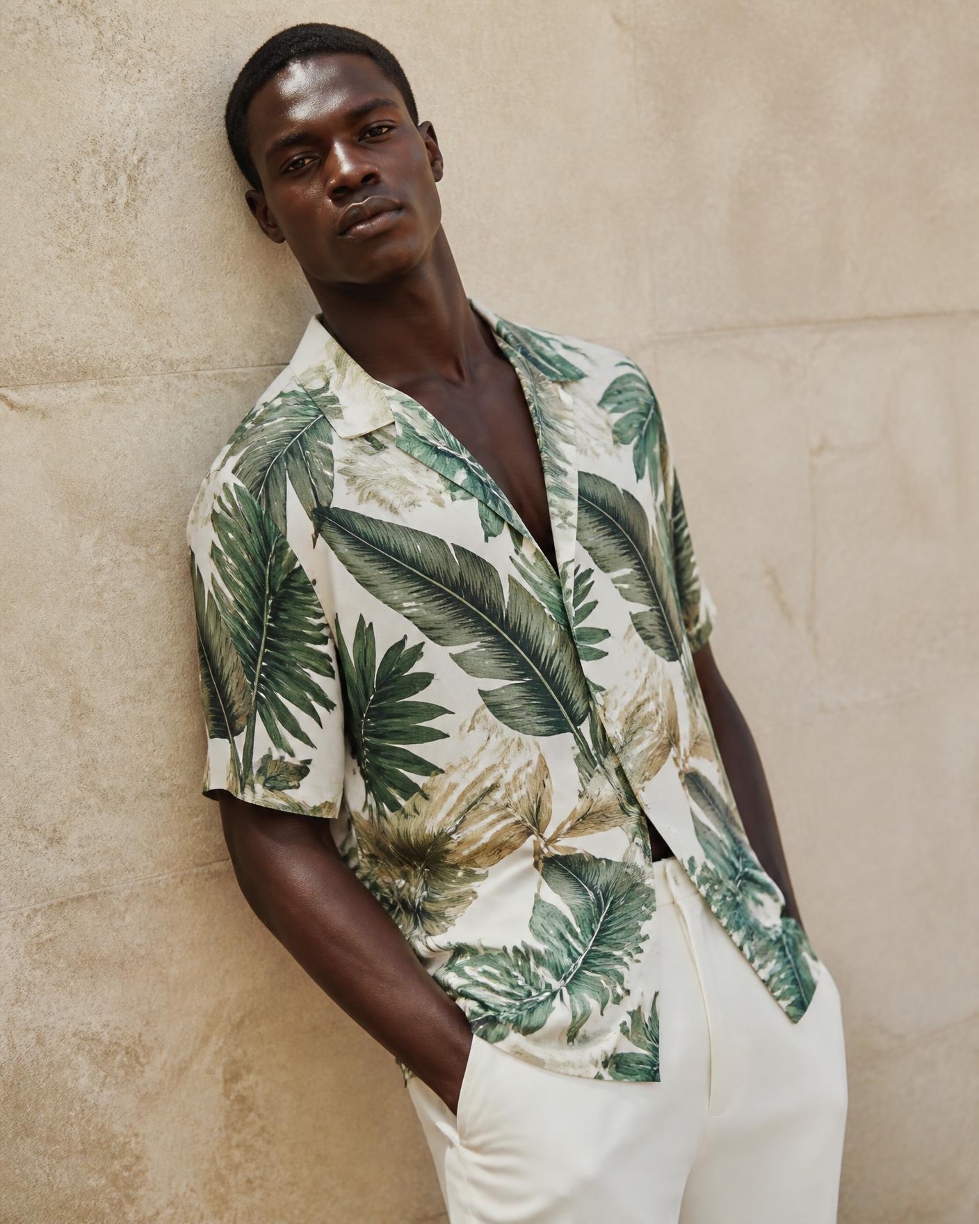 African model wearing the Tropical Leaf Printed Resort Shirt against a stone wall